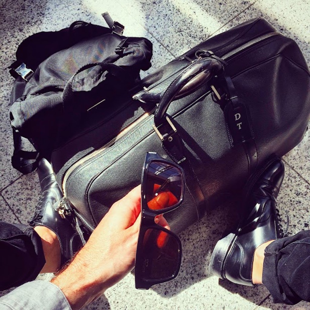 Weekend bag Taiga by Louis Vuitton, backpack by Prada, shoes by Church's, sunglasses by Saint Laurent
