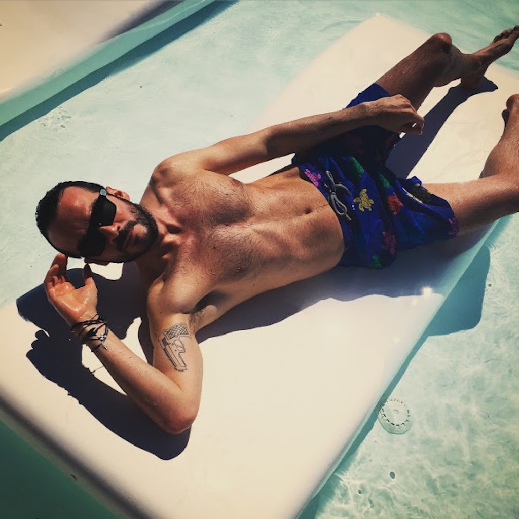 By the pool at Nikki Beach Porto Heli wearing VILEBREQUIN