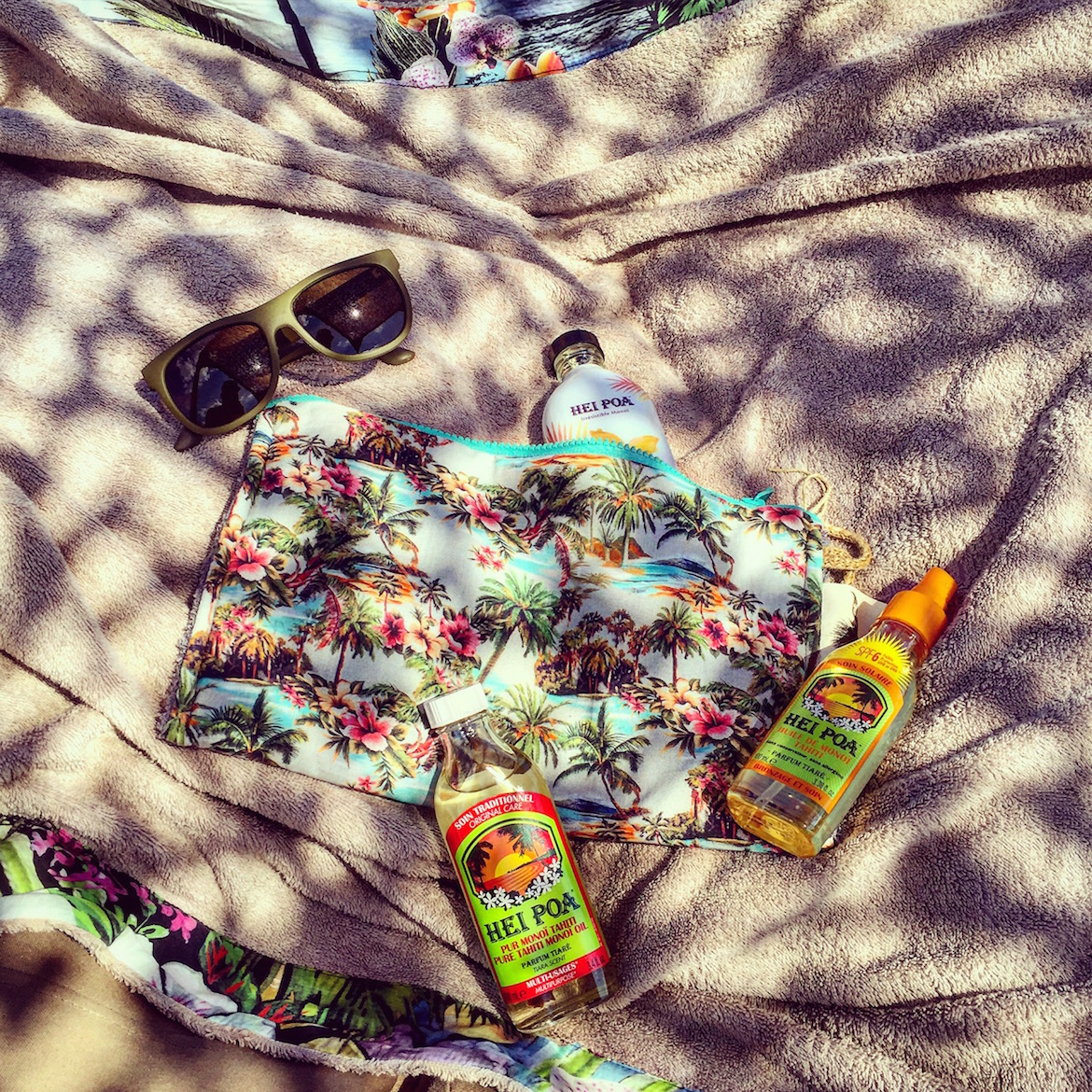 August top essentials: Hei Poa Monoi Oil. Beach kit & towel by the greek brand Sun of a Beach. Sunglasses by Vilebrequin.