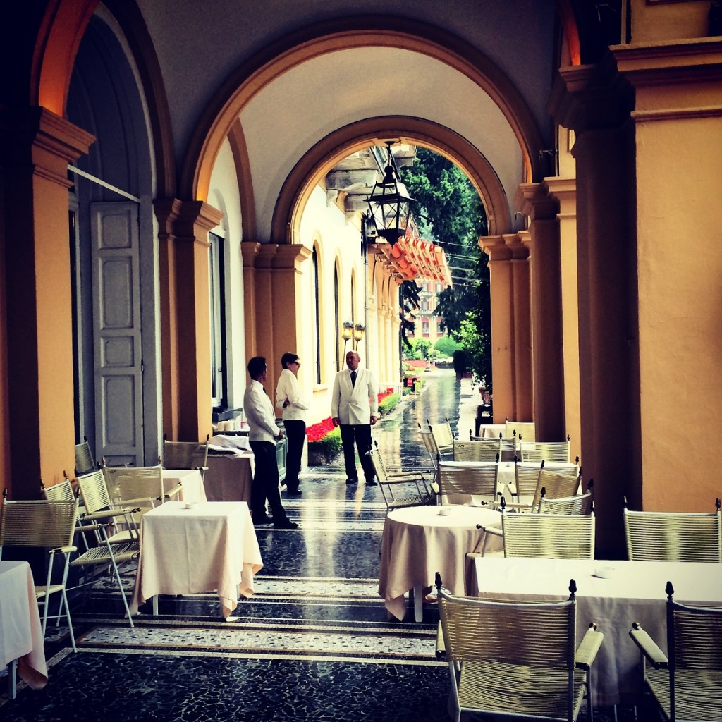 Waiters contemplaiting the rain dressed in made in Italy black & white uniforms.