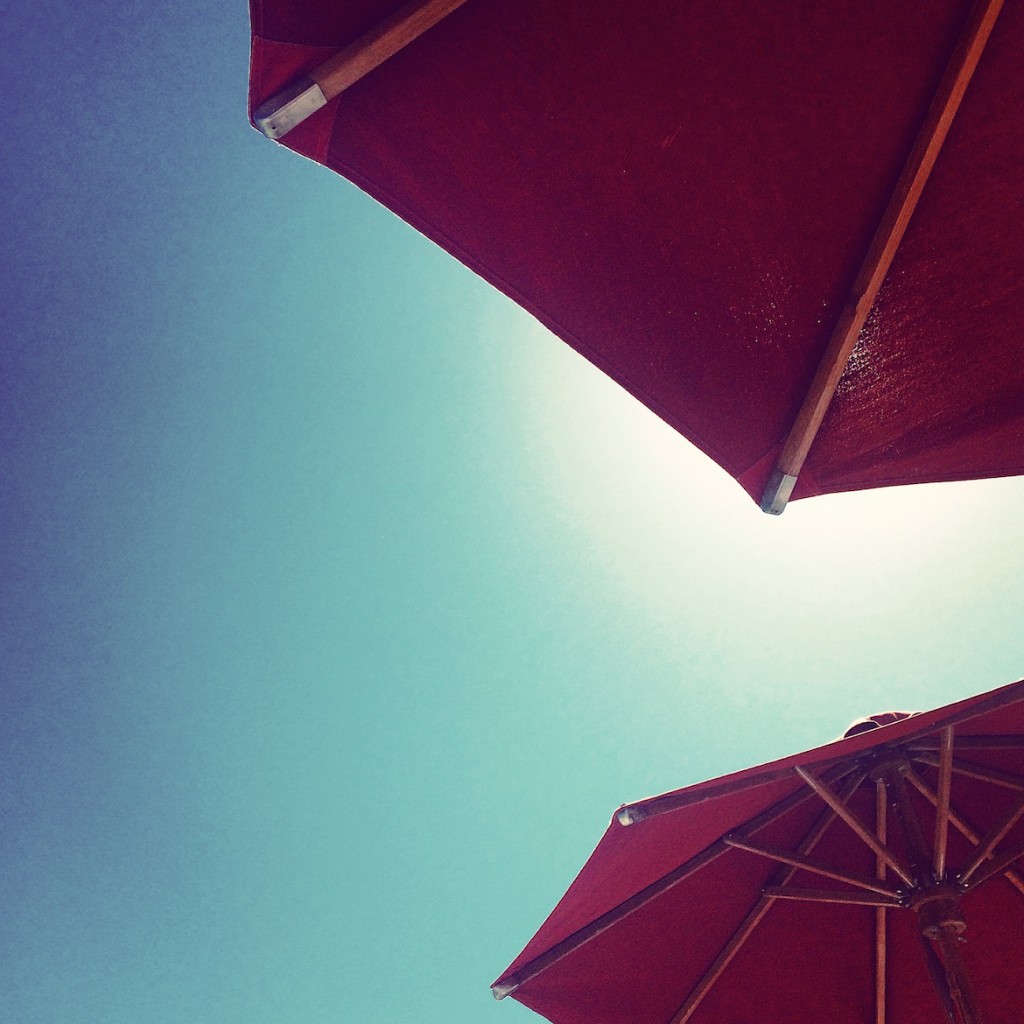 The signature red umbrellas of Nammos sea-side restaurant & club at Psarrou beach.